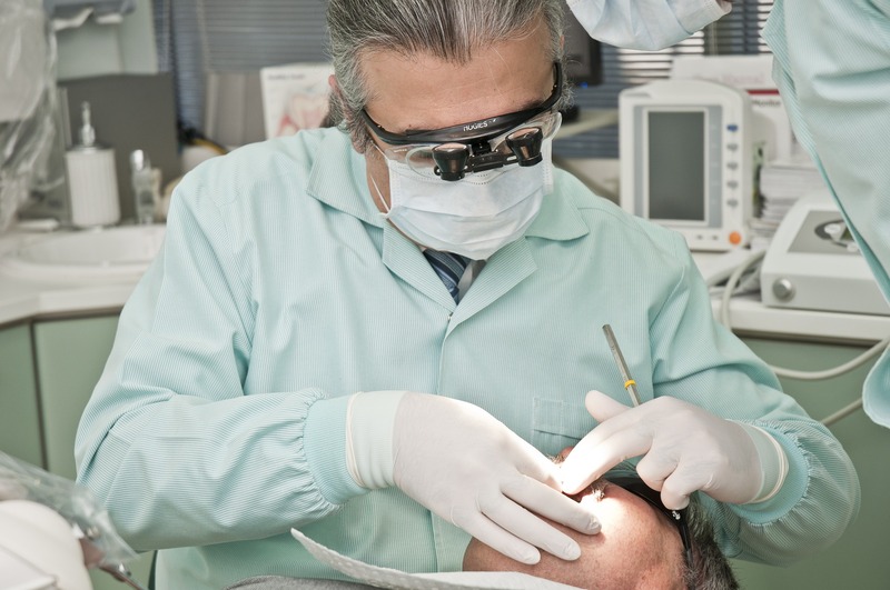 A dentist is examing a male patient (picture taken with Nikon D300 and Nikon AF-S DX 18-70mm F3.5-4.5 G IF-ED )