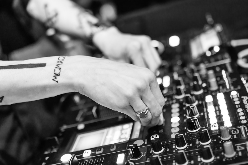 DJ with a tattoo on his forearm at his Pioneer mixer table (picture taken with Nikon D7100 and Nikon AF-S 35mm F1.4 G)