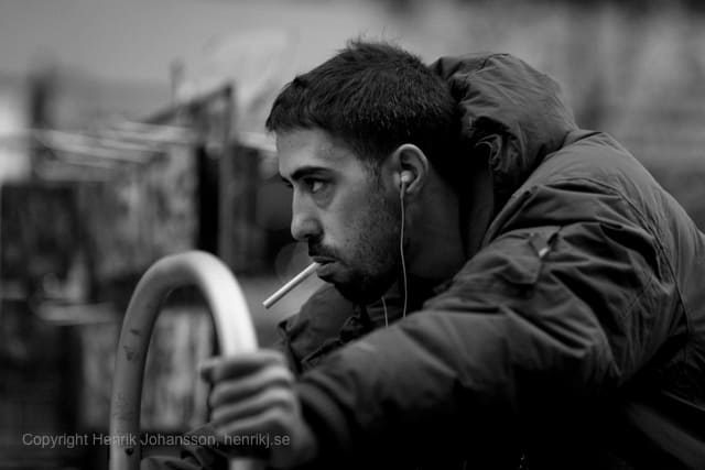 Man is pulling a heavy cart while smoking (picture taken with Canon EOS 5D Mark II and Canon EF 135mm f/2 L USM )