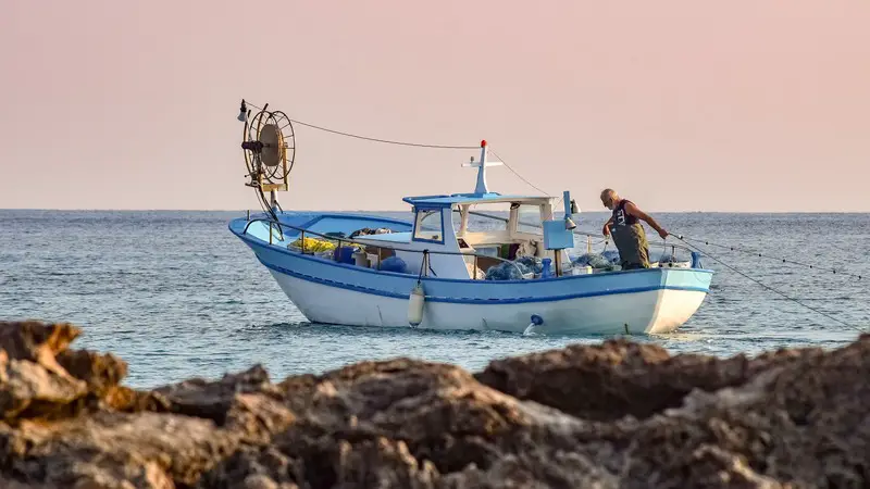 A fisherman is heading out in the morning and laying out his nets (picture taken with Nikon D3300 and Sigma 70-300mm F4-5.6 DG APO Macro (motorized))