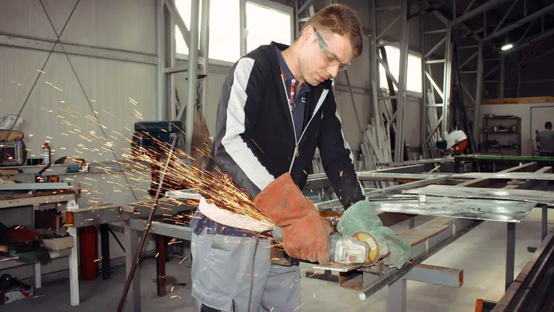 Carpenter is using a grinder to cut some metal (picture taken with Canon EOS 1200D and Canon EF-S 18-55mm F3.5-5.6 II )