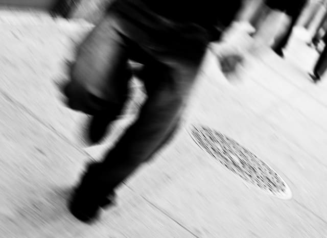 Guy is running on the sidewalk (picture taken with Canon EOS 1D Mark III and Canon EF 50mm F1.4 USM )