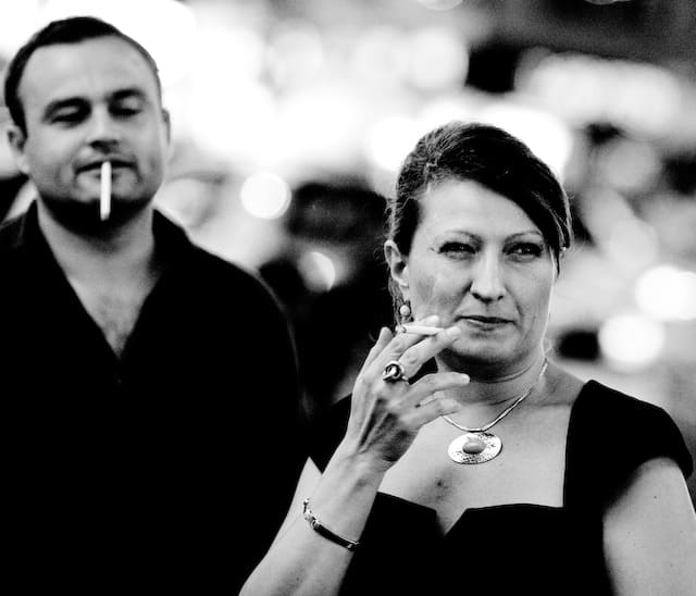 Guy that smokes is looking at a lady that also smokes (picture taken with Canon EOS 1D Mark III and Canon EF 135mm f/2 L USM )