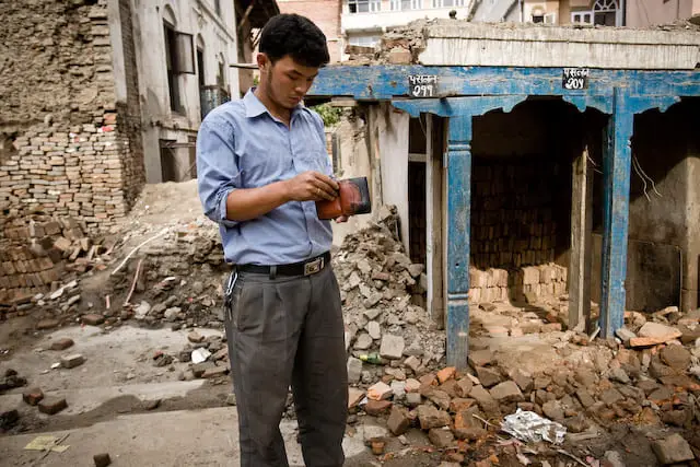 Guy inspecting his wallet among ruins (picture taken with Canon EOS 1D Mark III and Canon EF 16-35mm F2.8 L USM)