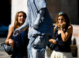 Two girls are frightened by street performer