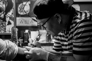 Tattoo Artist is working in his studio